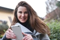 Woman in Gray Coat Holding White Smartphone