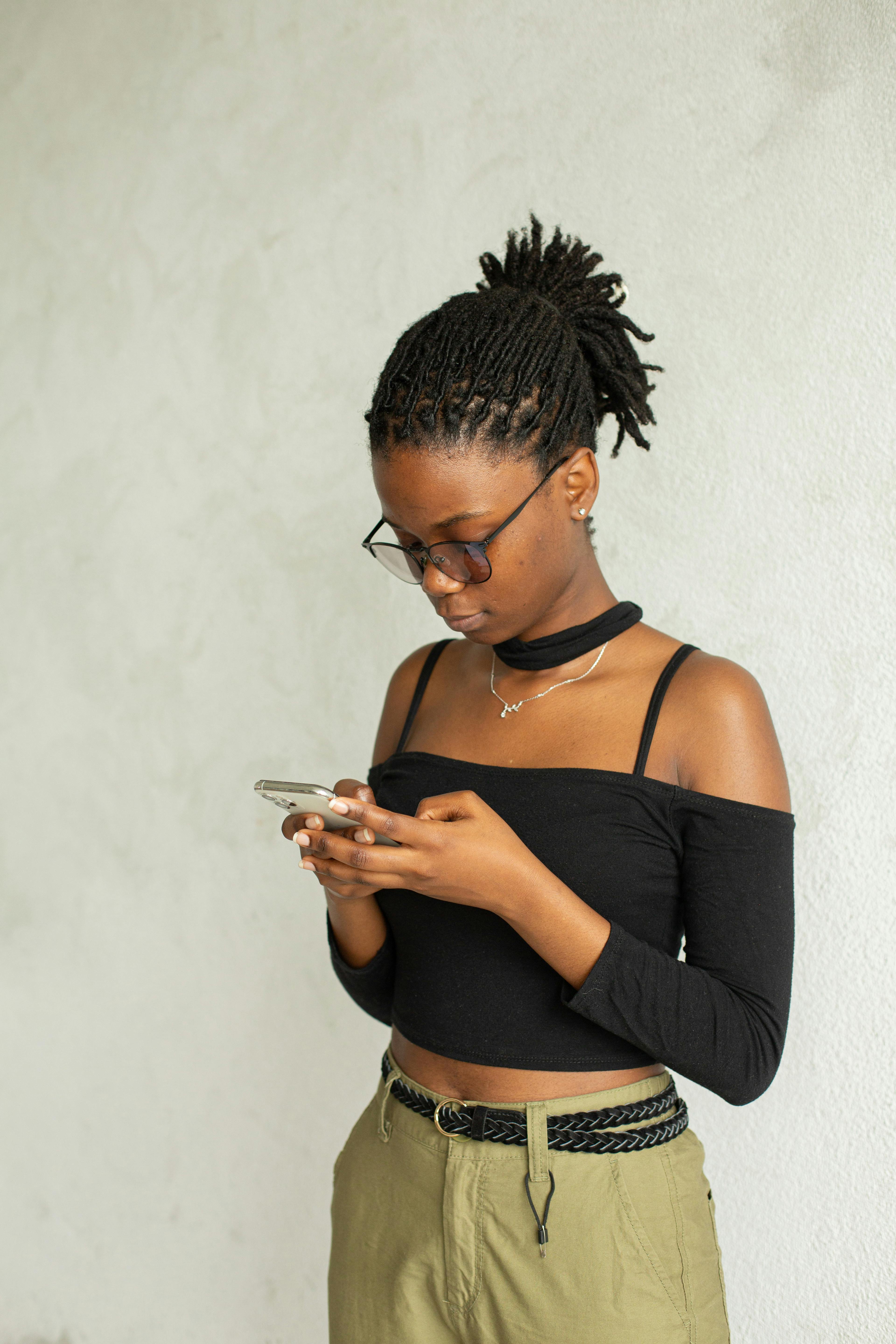 focused black woman using smartphone