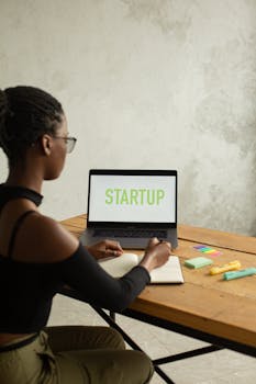 African American woman working on a startup project at home, using a laptop.
