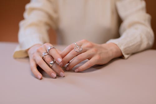 Close Up Photo of a Person Wearing Silver Rings