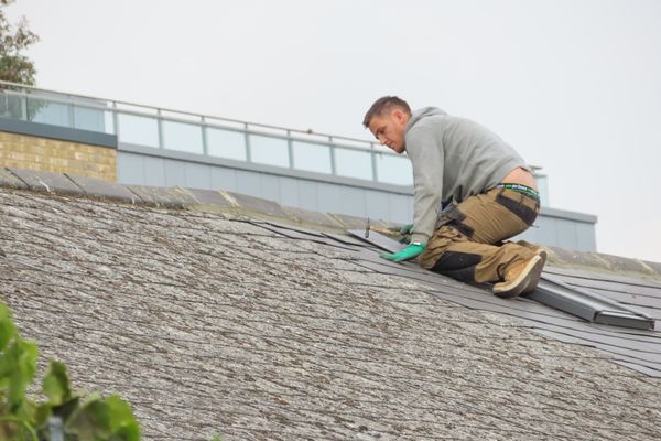 Handyman repairing roof tiles