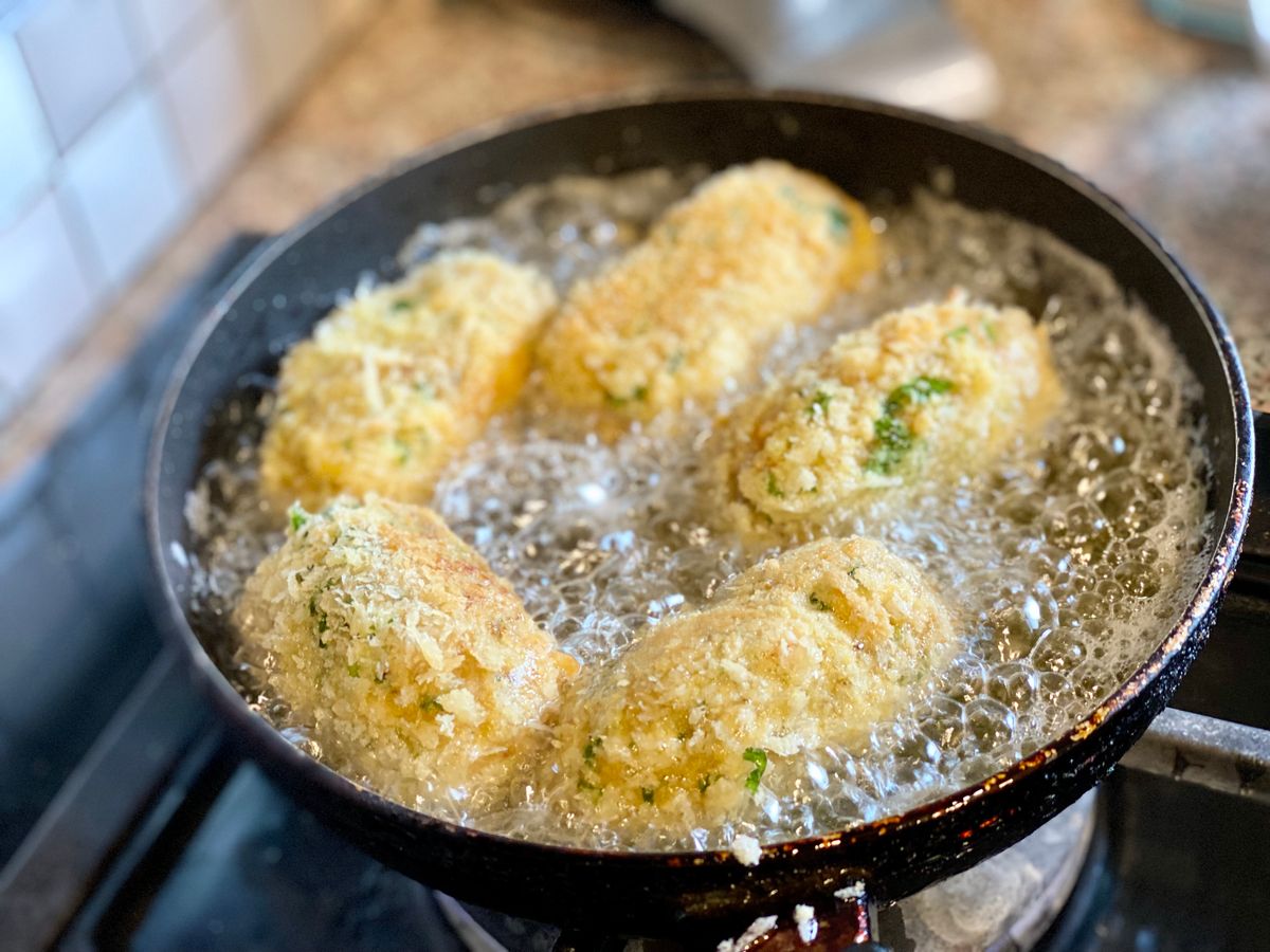 Croquetas friéndose en aceite caliente con burbuja limpia