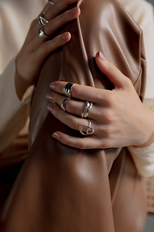 Free Person Wearing Silver Rings Holding Leather Garment Stock Photo