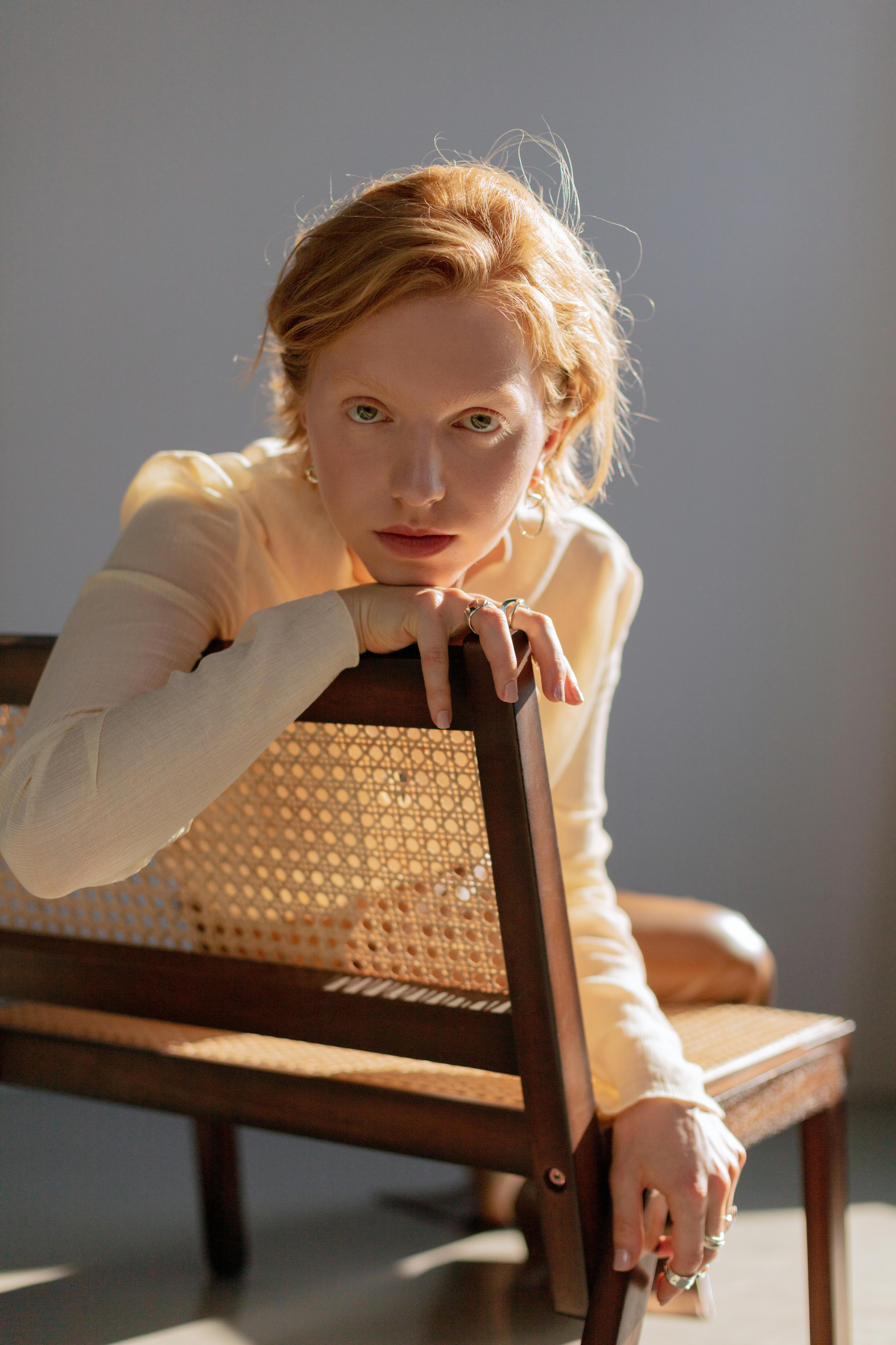 close up shot of a redhead woman sitting on wooden bench