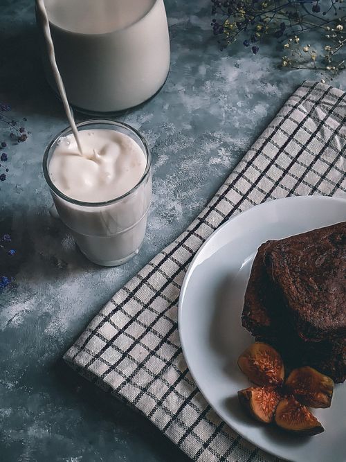 Free Appetizing chocolate brownie served with a glass of milk and figs on the side. Stock Photo