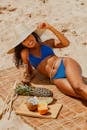 Woman in Blue Bikini Lying on Brown Sand