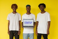 Man in White Crew Neck T-shirt holding Laptop