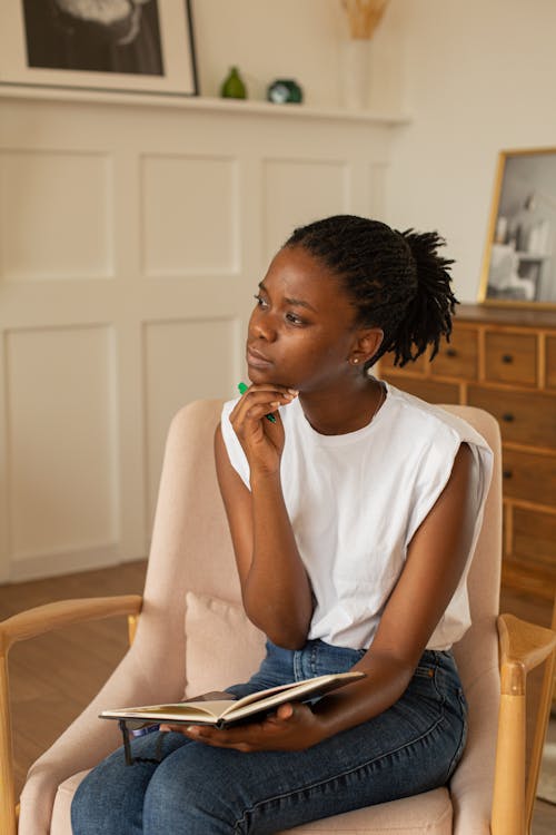 Pensive Woman sitting on an Armchair