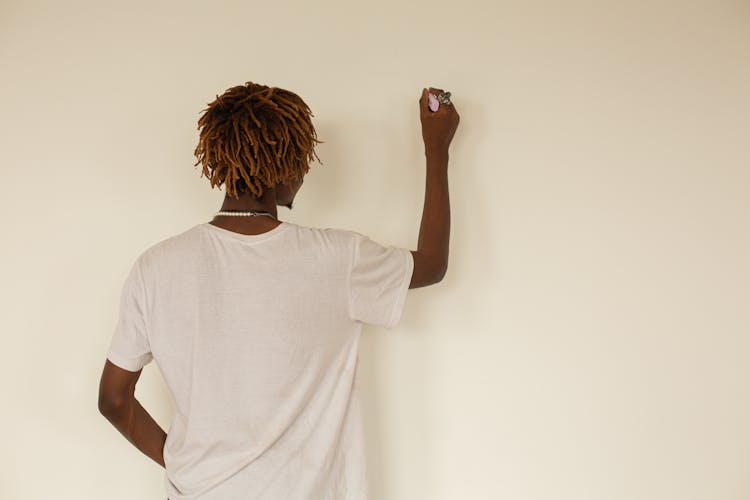 Man In White Shirt Writing On Wall