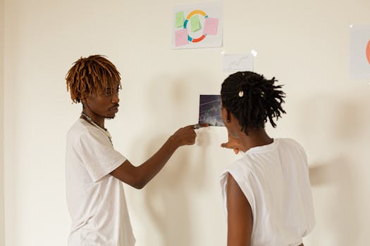 Two professionals discussing project management ideas using visual aids on a wall.