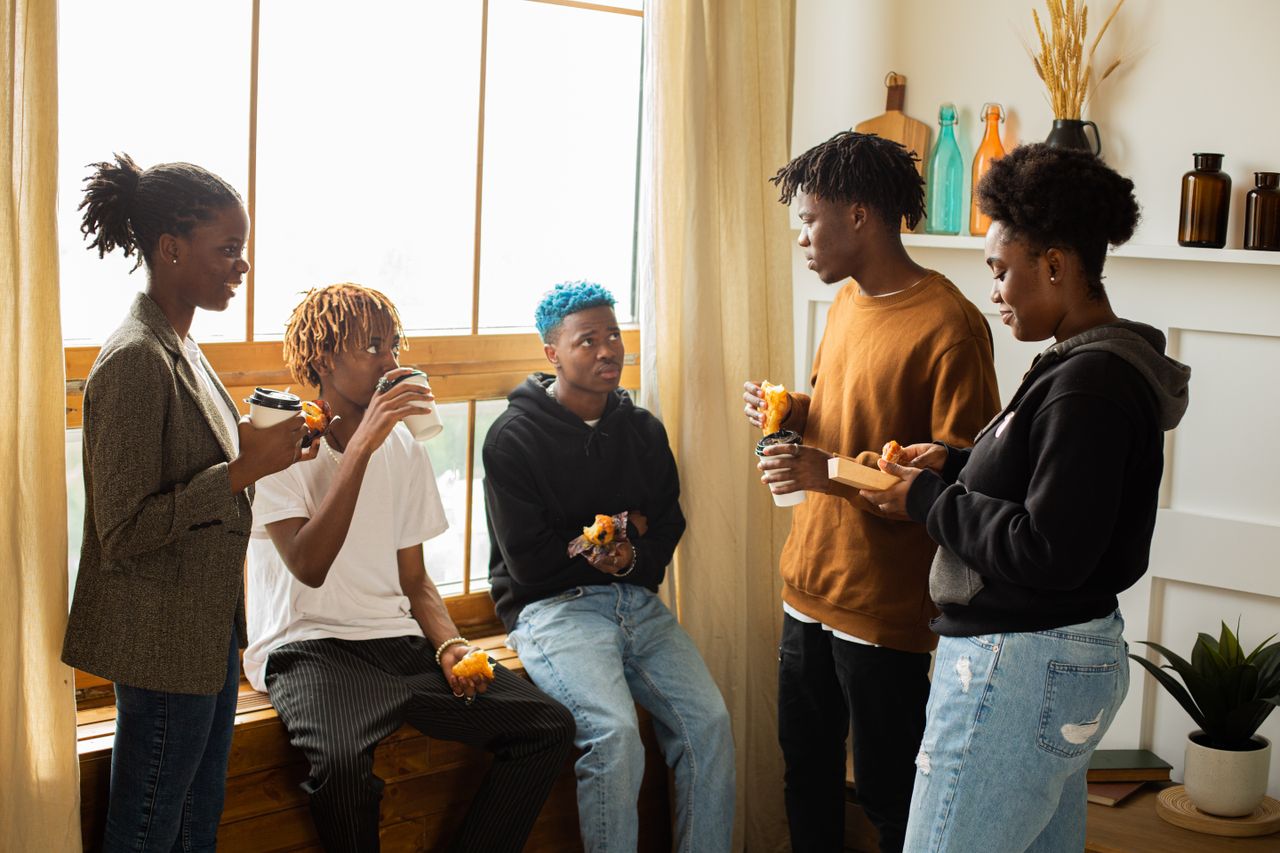a diverse group of friends chatting and enjoying coffee indoors during