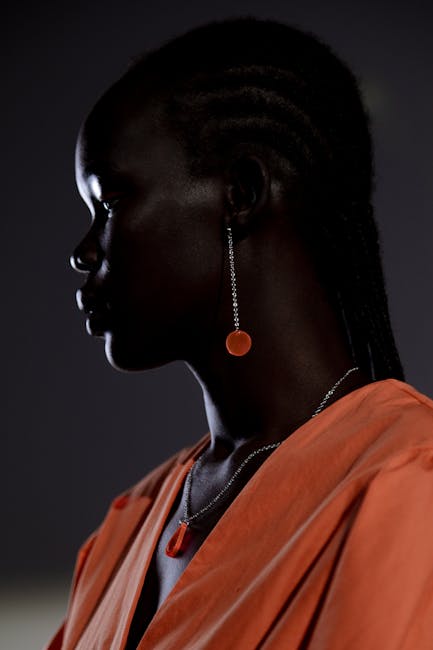 Stylish side view portrait capturing the elegance of a woman with stunning orange jewelry.