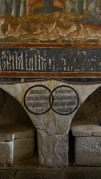 Detailed view of a Byzantine fresco and ancient script in a historic church interior.
