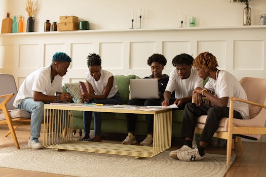 A group of young adults collaborating in a stylish workspace, focusing on teamwork and creativity.