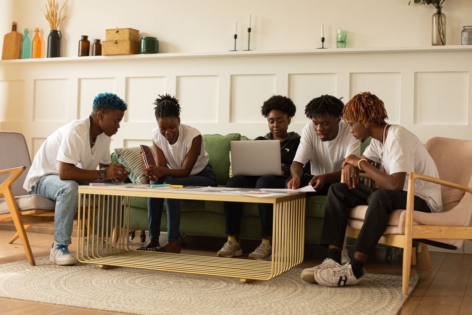 engraved gift ideas for best friends - A group of young adults collaborating in a stylish workspace, focusing on teamwork and creativity.
