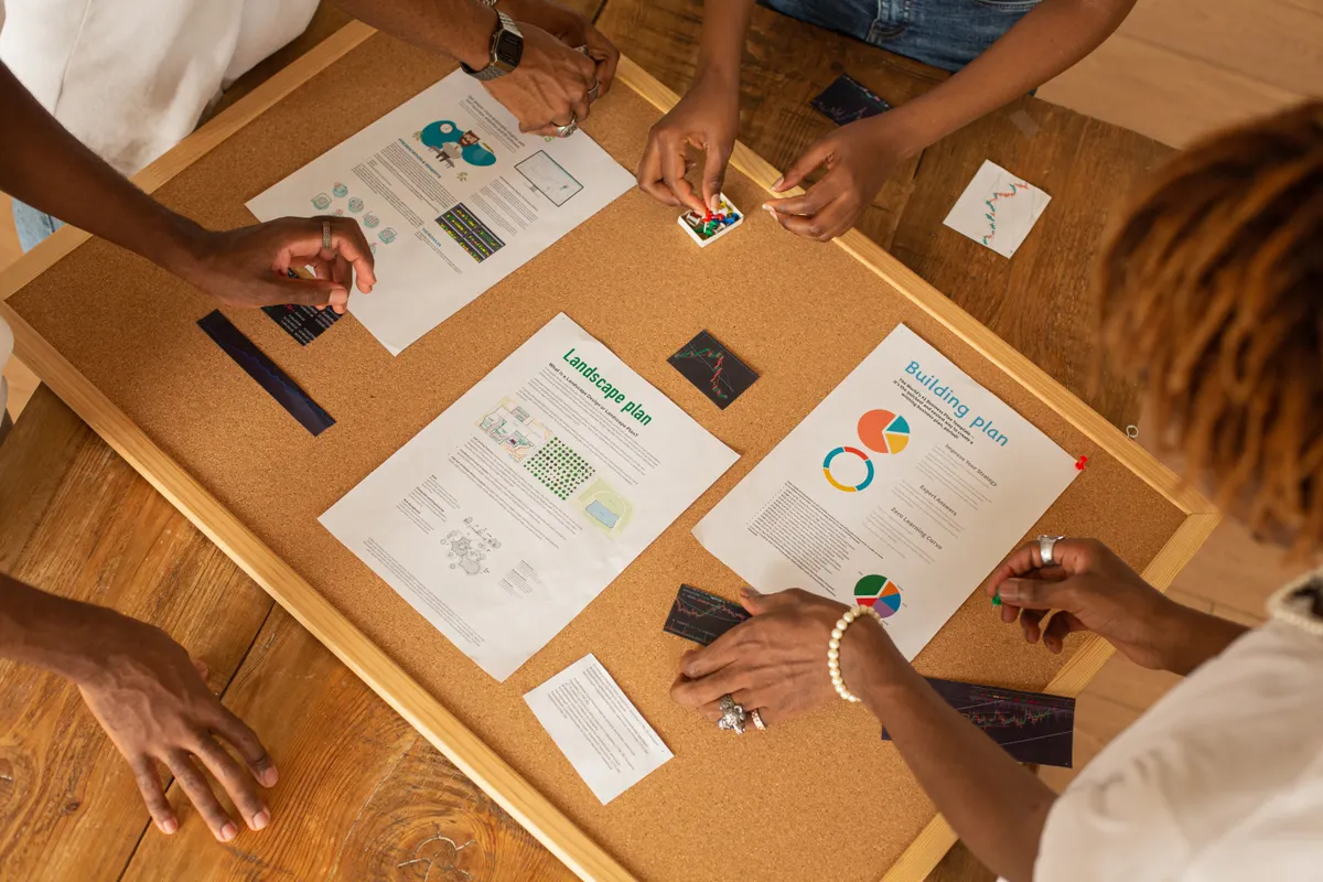 Team using an ai content generator to plan projects on a corkboard with charts.
