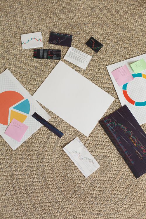 Free Overhead view of financial charts, graphs, and sticky notes on a carpet. Stock Photo