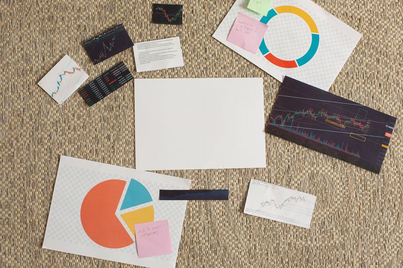 Flat lay of financial charts and sticky notes on a textured surface, ideal for planning and analysis concepts.