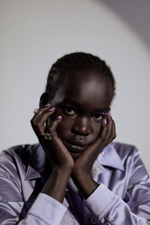 Free Elegant portrait of a pensive woman in a purple shirt against a soft background. Stock Photo