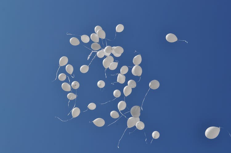 White Balloons Flying In The Sky