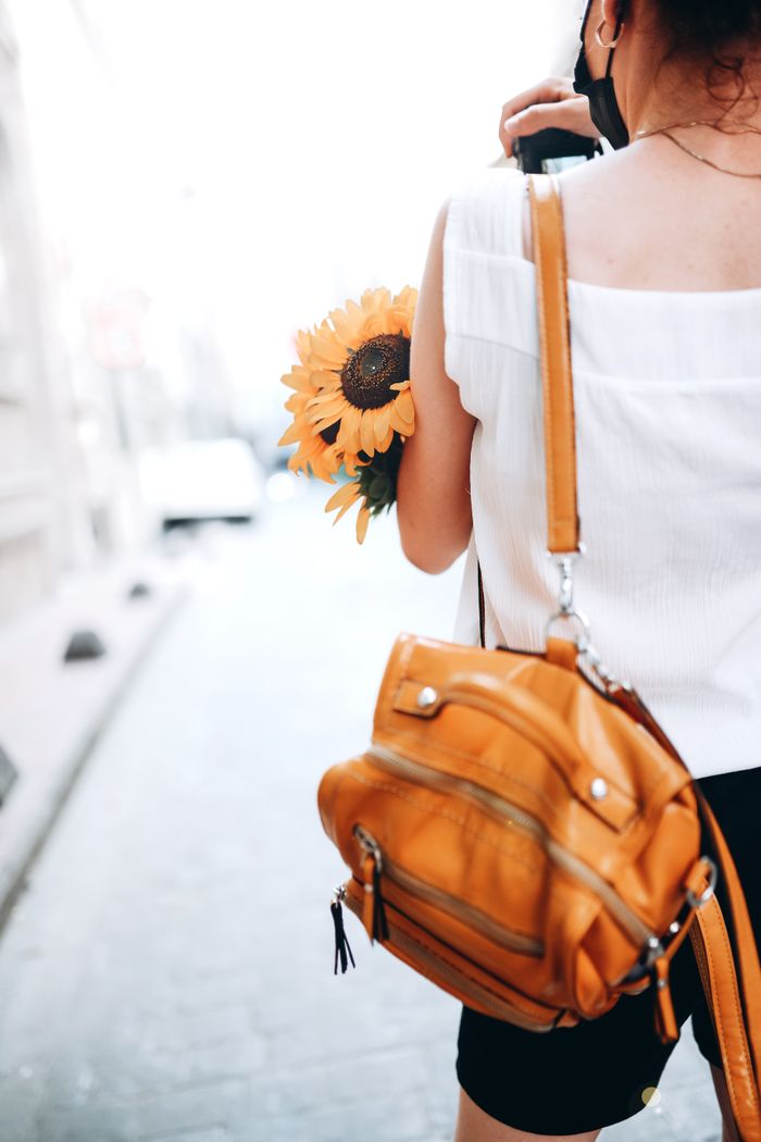 Tan leather shoulder bag worn on a city street, by Kader D. Kahraman on Pexels