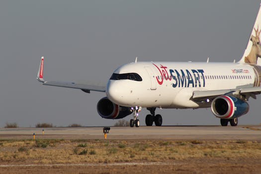 A JetSmart Airbus aircraft taxis on a runway under clear skies, ready for takeoff.