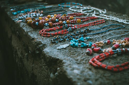 Close Up Photo of Beaded Accessories on Gray Surface