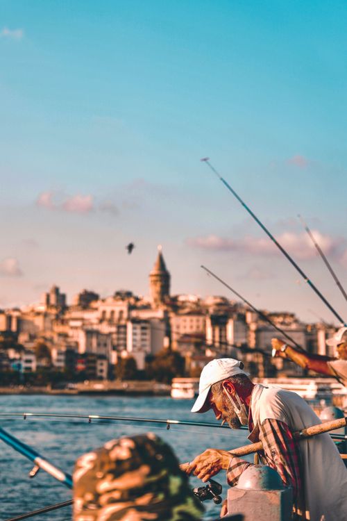Free A scenic view of people fishing on the Galata Bridge in Istanbul against a city backdrop. Stock Photo