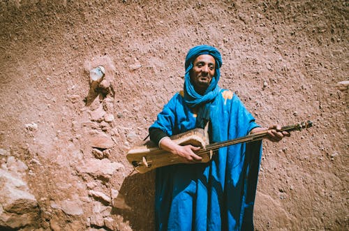 Hombre Vestido Con Top Azul Sosteniendo Un Instrumento De Cuerda Marrón