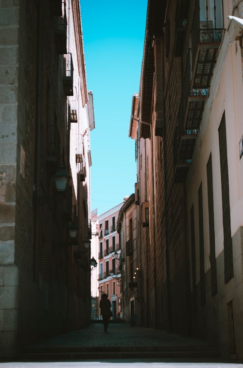 Person Walking Between of Houses