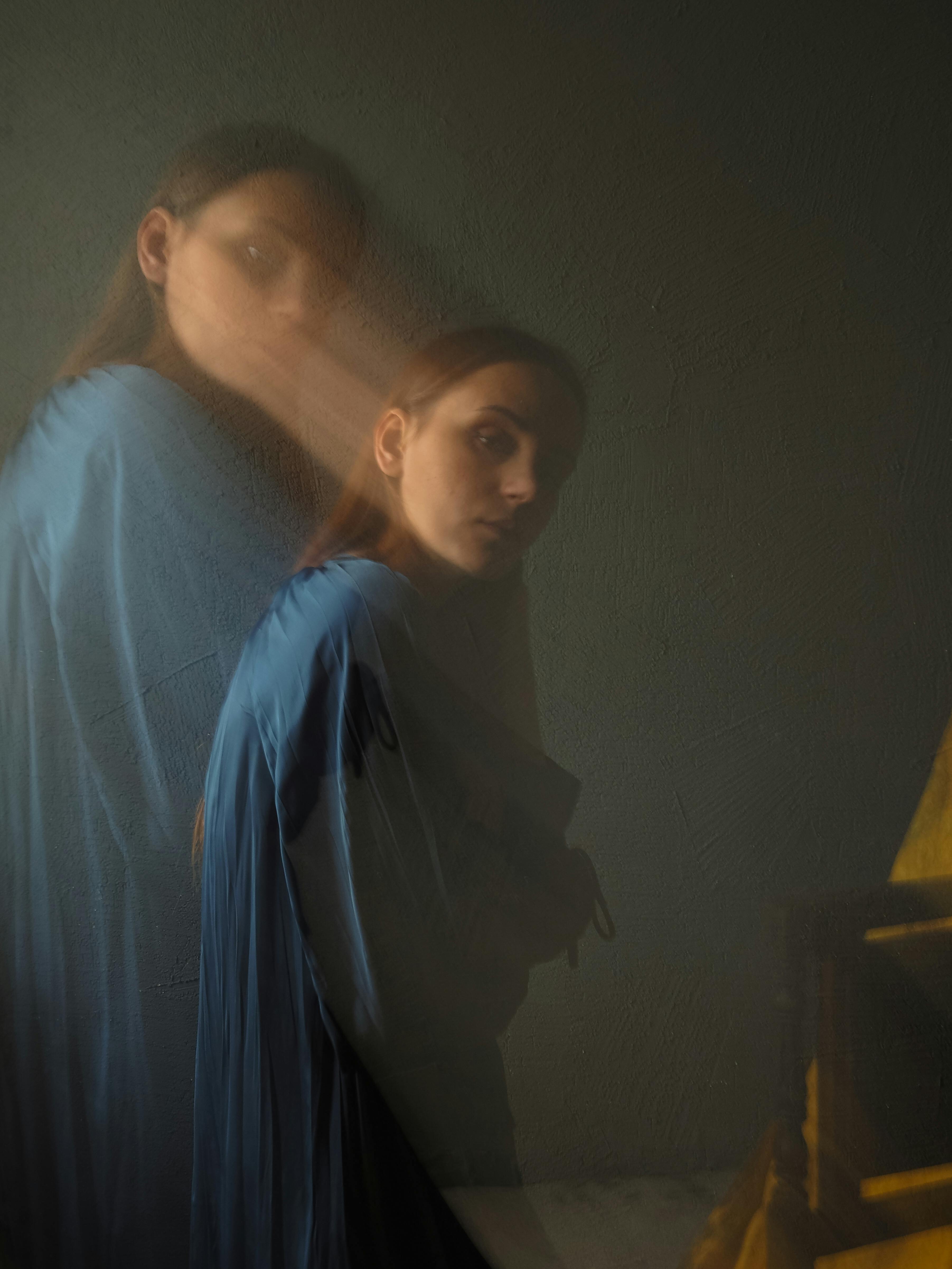 A mysterious artistic portrait of a woman captured with a dreamy double exposure effect, creating a ghostly appearance.