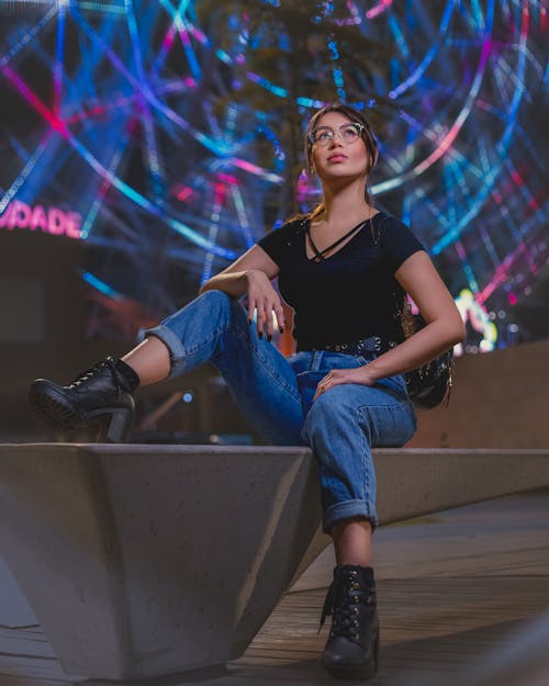 Woman in Black Top and Blue Denim Jeans Looking Upwards