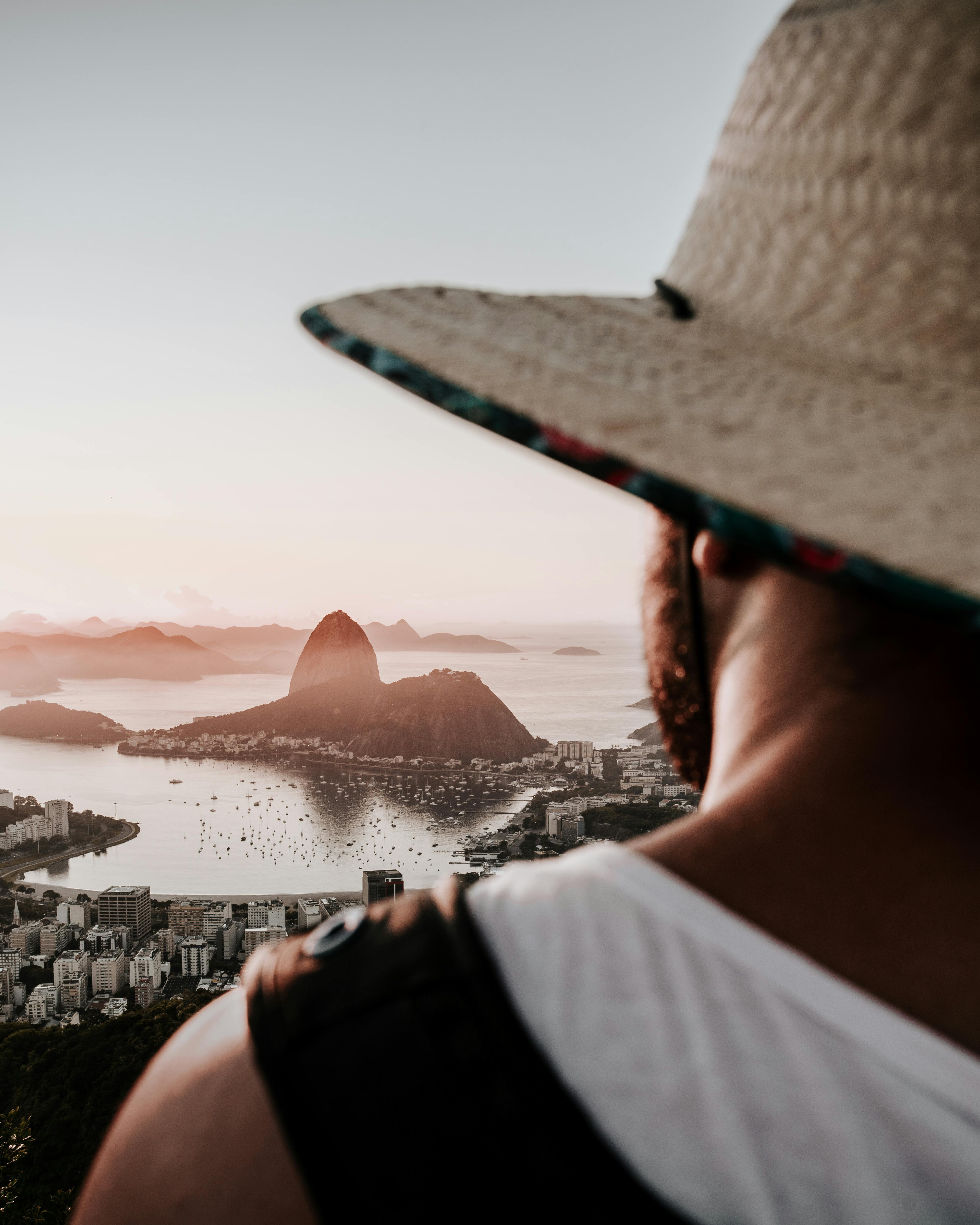 Traveler enjoying a stunning sunset view over Rio de Janeiro, with Sugarloaf Mountain in the distance.