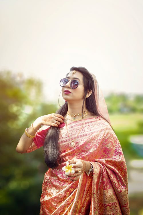 Selective Focus Photo of a Woman with Sunglasses Touching Her Hair