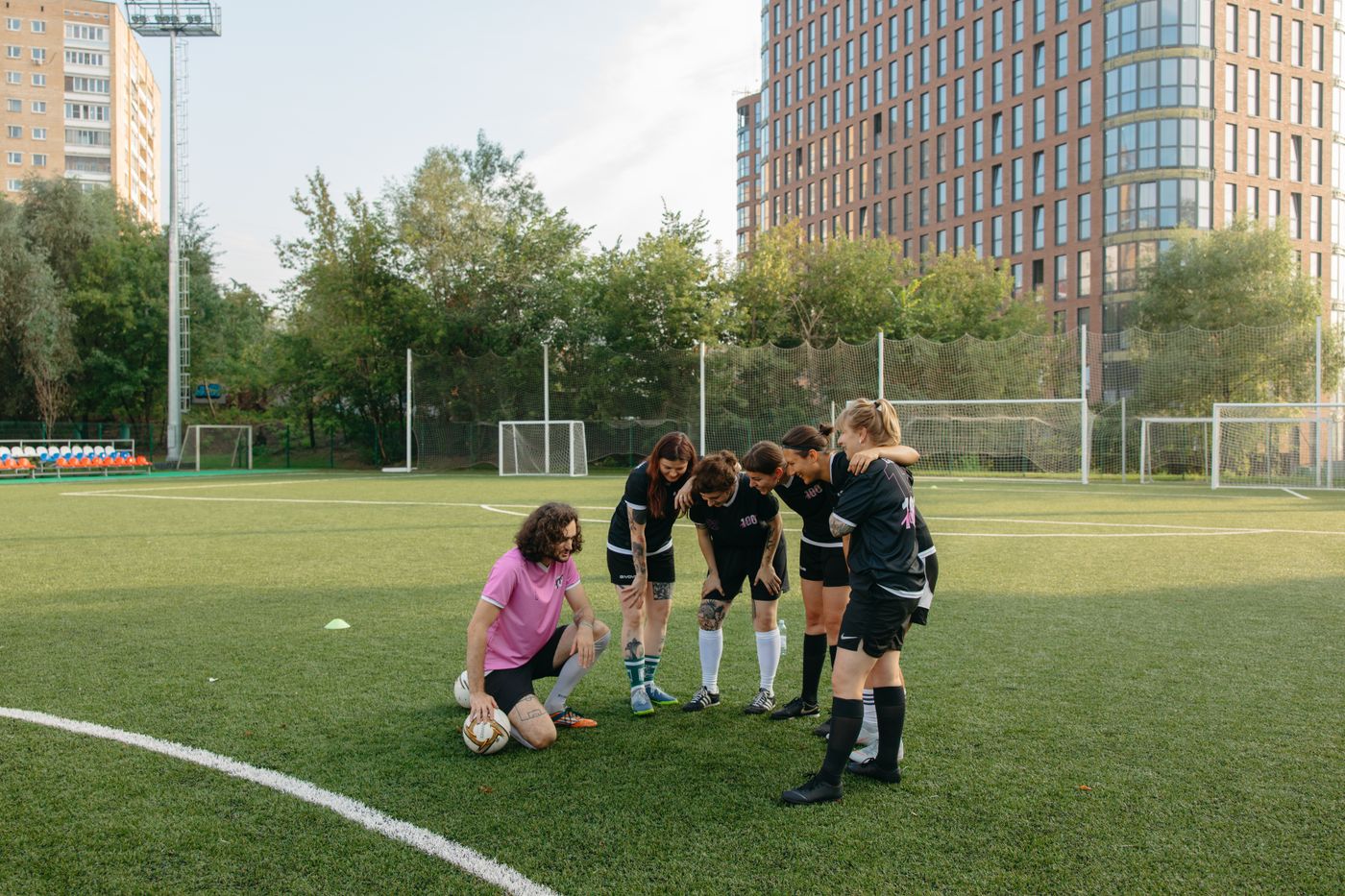 Coach and athletes gathered on a field before a training session