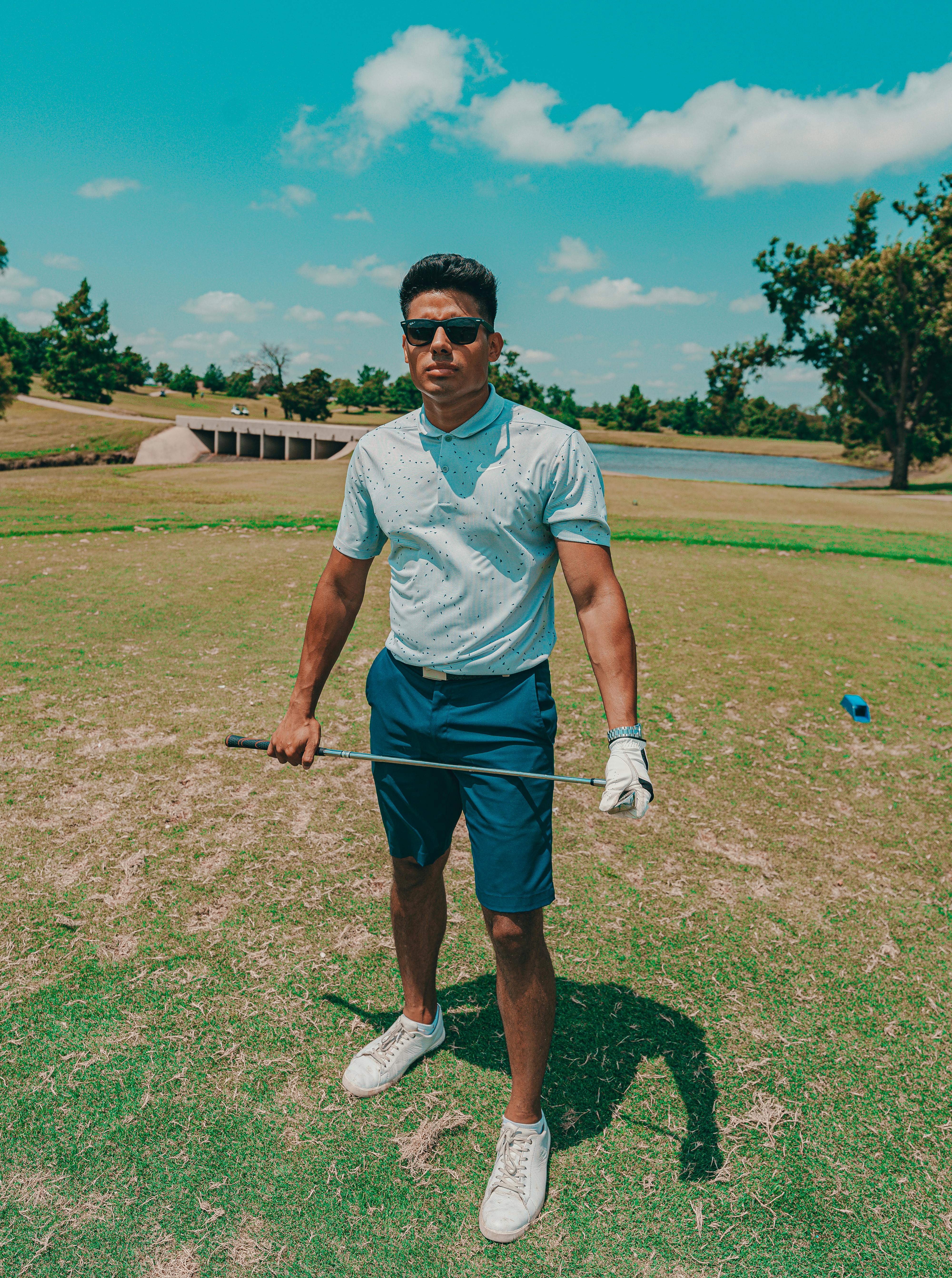 man wearing a polo shirt holding a golf club