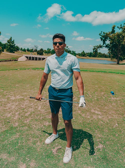 Free Man Wearing a Polo Shirt Holding a Golf Club Stock Photo