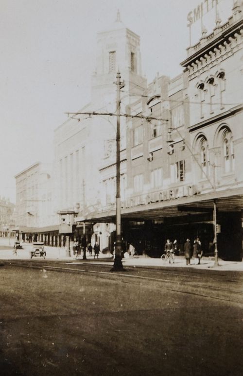 Free Old city street view featuring pedestrians and vintage architecture in a historic cityscape. Stock Photo