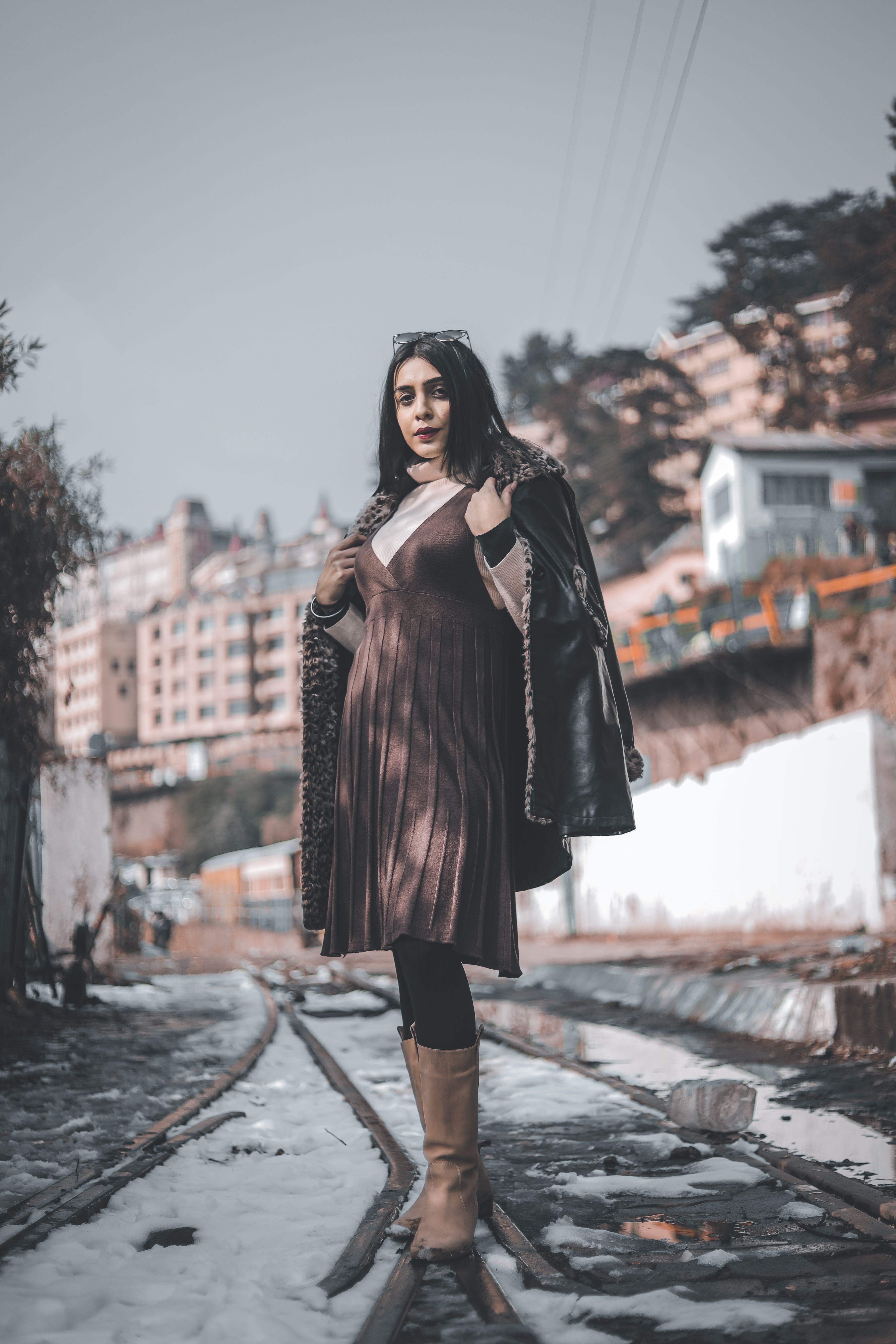 Winter wedding guest outfit with a long wool coat layered over an elegant evening dress