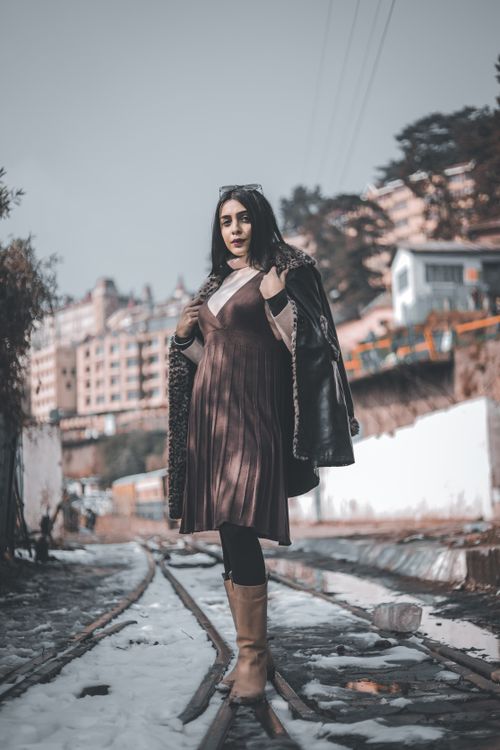Winter wedding guest outfit with a long wool coat layered over an elegant evening dress