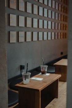 Chic cafe setting with iced drinks in plastic cups on a wooden table.