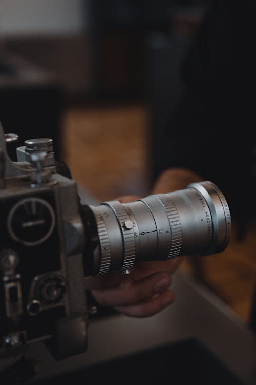A Hand Holding a Silver Lens of the Camera