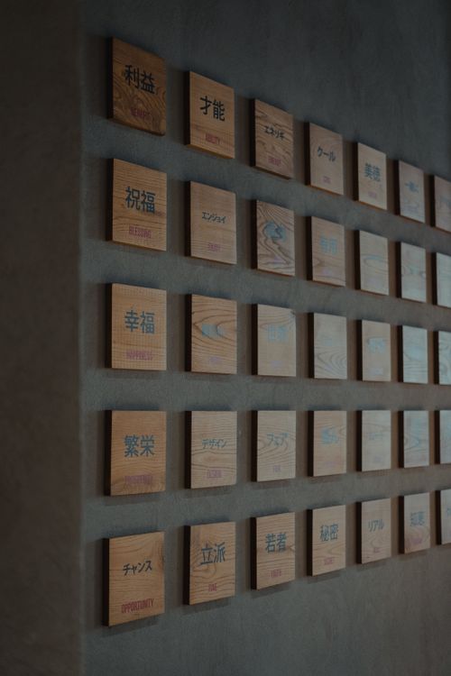 Free A stylish wall featuring wooden plaques with minimalist Chinese characters in a modern setting. Stock Photo