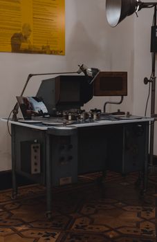 A vintage film editing console displayed in a museum with classic equipment and decor.