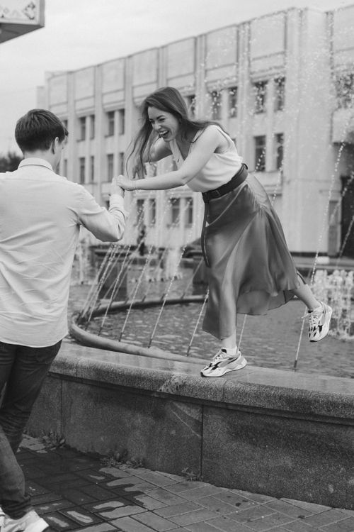 Free A young couple enjoying a playful moment by a fountain in Moscow, Russia. Stock Photo