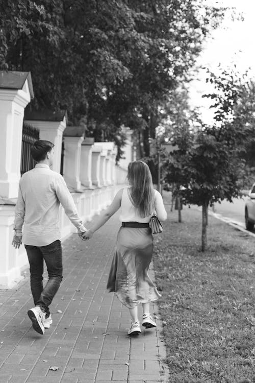 Man and Woman Walking on Pavement Holding Hands · Free Stock Photo