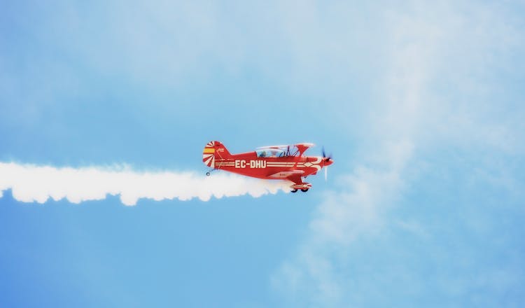 Red Plane Flying Under Blue Sky