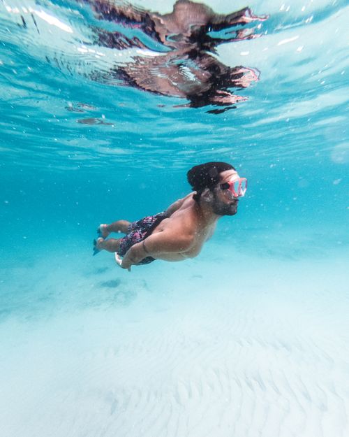 Free A bearded man swimming underwater in clear blue waters of Arraial do Cabo, Brazil. Stock Photo