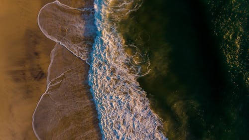 Aerial View of Waves Crashing on Shore