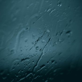 Abstract close-up of water droplets on a glass surface, creating a moody texture.